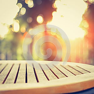 Round wood table top on blur bokeh background of sunlight