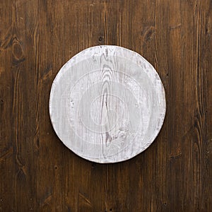 Round wooden plate on old wooden background