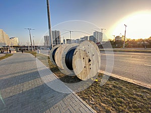 Round wooden skeins with electricity cable. the cable is wound on a large, wooden spool. construction site, cable laying