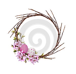 Round wreath from dry twigs with spring branches of peach flowers and leaves and Easter painted eggs