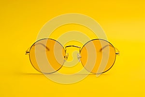 Round yellow tinted sunglasses on yellow photo