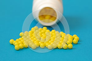 Round yellow vitamin C tablets on a blue background. Ascorbic acid close-up. Vitamin C for the treatment and prevention of colds.