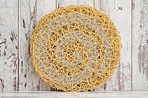 Round, Yellowish Golden Mat with a Textured Surface on White Background photo