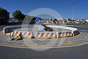 Roundabout with concrete barrier and blue traffic sign in the city of Heraklion in Greece near the port.
