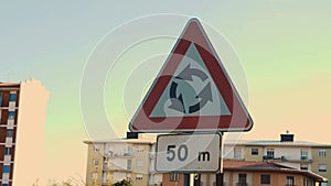 Roundabout sign with a plate indicating 50 meters, indicating that ahead is a roundabout. Road signs in the city along