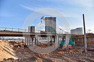 Roundabout and traffic bridge construction. Construction highway ramps and bridgeworks. Crane for formwork on bridge project works