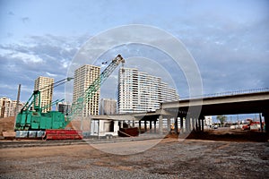 Roundabout and traffic bridge construction. Construction highway ramps and bridgeworks. Crane for formwork on bridge project works
