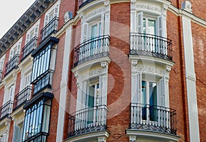 Rounded corner with elegant windows and balconies on classical building in Chueca district downtown Madrid, Spain. Classy Spanish photo