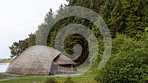 Roundhouse situated near a tranquil body of water, surrounded by lush trees