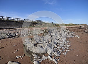 A roundly eroded light grey rock formation on the Sandy Beach near Easthaven.