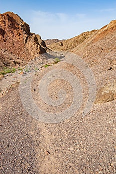 The route or walking path, track through the yellow red rocky landscapes of Eilat desert