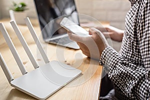 Router and a man using smartphone onliving room