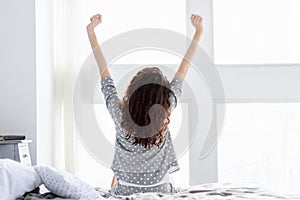 Daily routine. Young female with curly hair weak up in morning