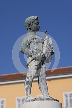 Boy with Fish fountain on Marshal Tito Square in front of Tower with city clock, Rovinj, Croatia