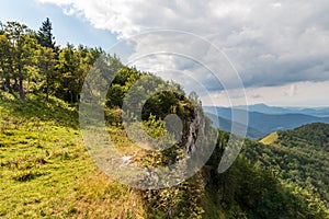 Rovné skaly se stromy a kopci na pozadí v pohoří Malá Fatra na Slovensku