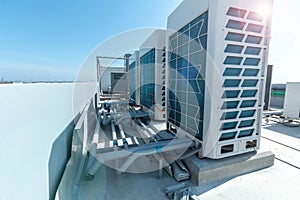 A row of air conditioning units on rooftop with blue sky