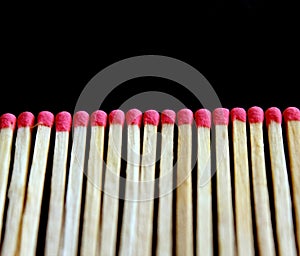 Row of aligned fire matchsticks on black background