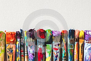 Row of artist paintbrushes closeup on canvas.