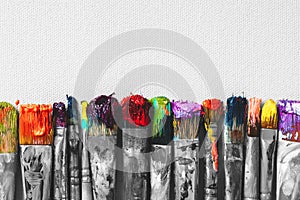 Row of artist paintbrushes with colorful bristle closeup photo