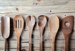 Row of assorted old wooden kitchen utensils