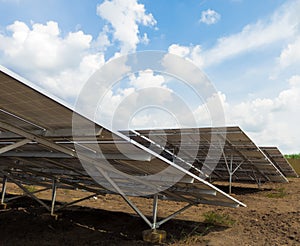 Row of back side view photovoltaic solar panels / modules at solar power station