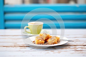 row of baklava with espresso on a bistro table