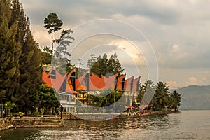 A row of Bataknese houses and villas on the shore of Lake Toba photo