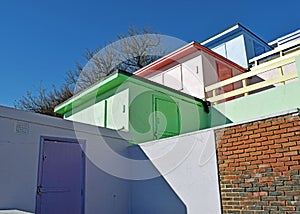 A row of beach huts with a blue sky background