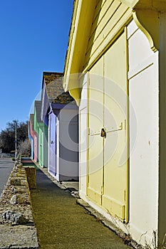 A row of beach huts with a blue sky background