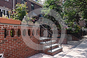 Row of Beautiful Old Brick Homes with Stairs along a Sidewalk in Astoria Queens New York