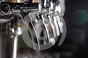 A row of beer taps in a beer bar close-up. Beer bottling in the restaurant.