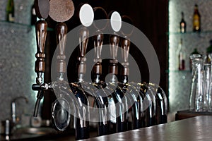 Row of beer taps on a stainless steel keg in a pub