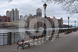 Row of Benches along the East River at Roosevelt Island and looking towards the Upper East Side Skyline of New York City