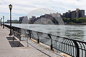 Row of Benches on the Upper East Side with a view of the Roosevelt Island Skyline along the East River in New York City