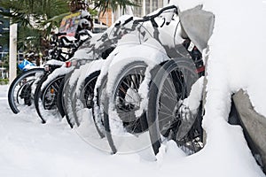 Row of bicycles covered with snow