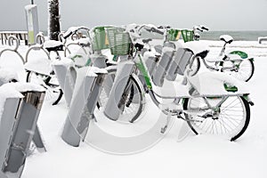 Row of bicycles covered with snow at the sea side