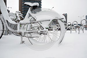 Row of bicycles covered with snow at the street