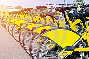 Row of bicycles parked. Row of parked colorful bicycles. Rental yellow bicycles. Pattern of vintage bicycles bikes for rent on