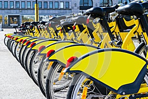 Row of bicycles parked. Row of parked colorful bicycles. Rental yellow bicycles. Pattern of vintage bicycles bikes for rent on sid