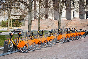 Row of bikes parked for hire, city bikes rent parking, public bicycle sharing system