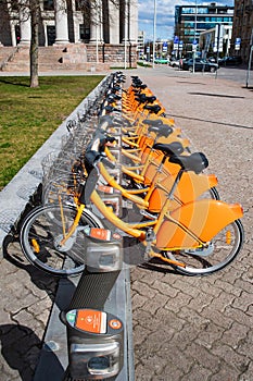 Row of bikes parked for hire, city bikes rent parking, public bicycle sharing system