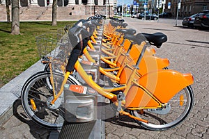 Row of bikes parked for hire, city bikes rent parking, public bicycle sharing system