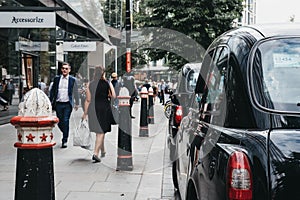 Row of Black cabs parked on a side of the road in City of London, London, UK.