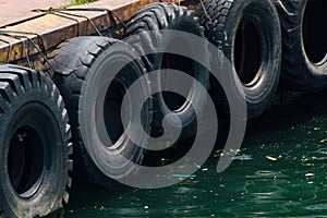 Row of black car tires used as boat bumpers