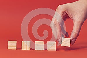 Row blank wooden blocks on a red background with copyspace for your text, letters or numbers.