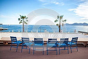Row of blue chairs in front of the sea in Cannes