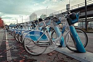 Row of blue Shaw Go Mobi bikes lined up near skytrain in Downtown Vancouver Canada