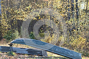 A row boat tied up on shore of autumn lake