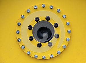 Row of bolts on a yellow tractor wheel