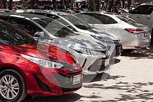 Row of brand new cars toyota yaris lined up outdoors in a parking lot